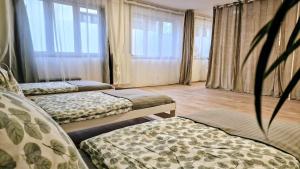 two beds in a room with windows at Orientarium Atlas Arena Family House in Łódź