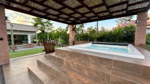 a swimming pool in a patio with a pergola at Pousada Salto Donner in Rio Forcação