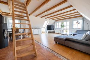 un soggiorno con scala a chiocciola in un soppalco di Haus "Zur Düne" a Norddorf