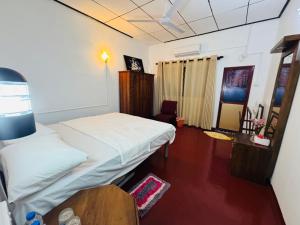 een kleine kamer met 2 bedden en een tafel bij Browns Hill Matara in Matara