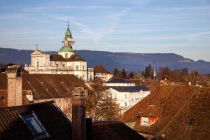 a large white building with a green turret on top of roofs at Hotel Roter Ochsen in Solothurn