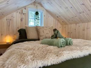 - un ours en peluche assis sur un lit dans une pièce dans l'établissement Pur Nature Garthby et Sauna, à Saint-Gérard