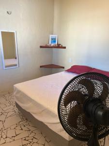a bedroom with a bed with a fan on it at Aconchego Praia do Balbino in Cascavel