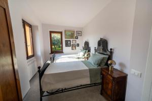 a bedroom with a bed and a wooden dresser at Uliveto Moriondo in Salò