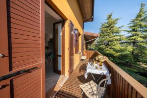 a wooden balcony with a table and chairs on it at Uliveto Moriondo in Salò