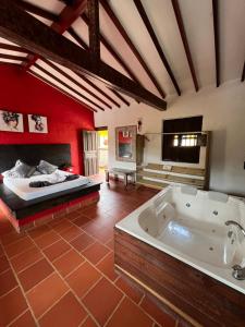 Habitación grande con bañera y cama. en Hotel La Choza, en El Peñol