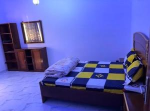 a bedroom with a bed with a blue and yellow at Superetoile in Rufisque