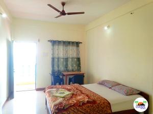 a bedroom with a bed and a ceiling fan at Oasis Arambol in Arambol