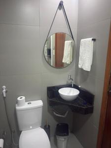 a bathroom with a sink and a toilet and a mirror at Suíte Doce Recomeço da Alice in Arraial do Cabo +7 photos