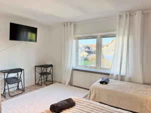 a bedroom with two beds and a tv and a window at Workers Big Villa - 5 BR - 2 Bath - 10 min to Volvo in Gothenburg