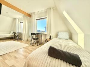 a white bedroom with a bed and a window at Workers Big Villa - 5 BR - 2 Bath - 10 min to Volvo in Gothenburg