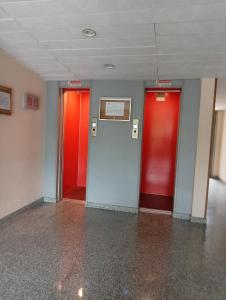 Eva Studio Apartment Arese Rho-Fiera Milano Galeazzi في أريسي: مصعدان بأبواب حمراء في غرفة فارغة