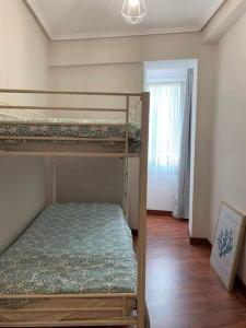 a bedroom with two bunk beds and a window at Singular piso junto al puerto - Arostegi Etxea in Bermeo