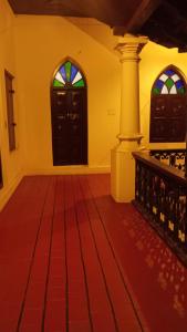 a room with two doors and a red floor at Anna's Heritage bungalow in Alleppey +19 photos