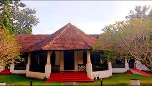 a house with a red staircase in front of it at Anna's Heritage bungalow in Alleppey