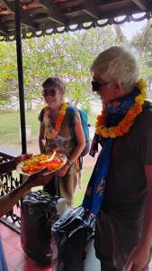 阿勒皮Anna's Heritage bungalow的一名女子端着一盘食物