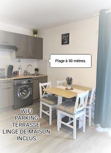 une cuisine avec une table et des chaises dans une pièce dans l'établissement Charmant studio climatisé 24 m2 terrasse à 100m de la plage, à Saint-Mandrier-sur-Mer