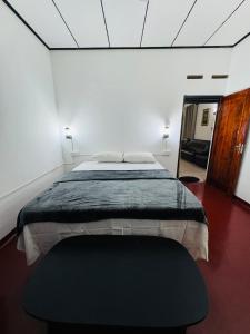 een slaapkamer met een groot bed en een groene deken bij Browns Hill Matara in Matara
