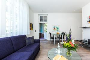 a living room with a blue couch and a glass table at Villa Höger in Boltenhagen