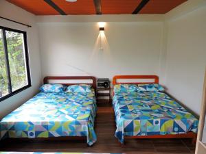 En eller flere senge i et værelse på Cabaña Manaos Salento