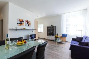 a living room with a glass table and blue chairs at Villa Höger in Boltenhagen