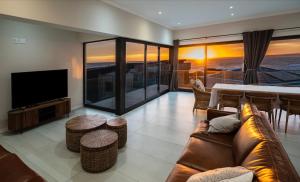 a living room with a couch and a flat screen tv at Escape to Paradise in Mossel Bay
