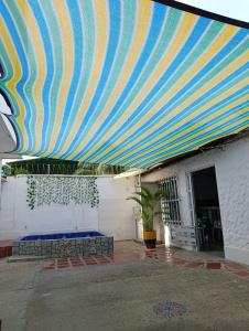 MaizalにあるApartamentos en Sabanilla, Colombia -Tu Escapada Ideal!の建物の上にある大きな青と黄色の縞模様の天蓋 +6枚の写真