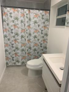 a bathroom with a shower curtain with a toilet at Peace and Quiet Dorm Rooms - Free Breakfast DIY Waffles - Free Dinner - Free Coffee - Longterm Ok! in Miami