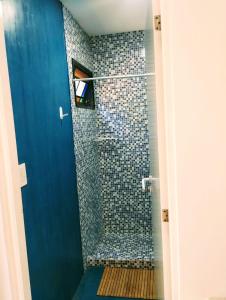 a bathroom with a shower with a blue door at Big Sur in Mar Azul