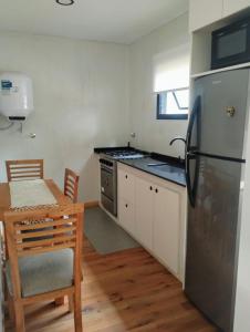 a kitchen with a stainless steel refrigerator and a table at Big Sur in Mar Azul