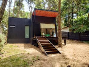 a black house with a wooden staircase in the woods at Big Sur in Mar Azul