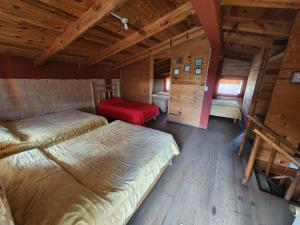 a room with two beds in a room with wooden ceilings at Cabañas La Moneda in Rancho La Carolina