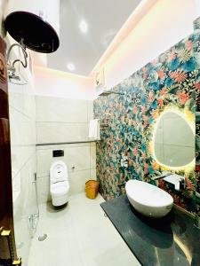 a bathroom with a toilet and a sink and a mirror at The Family Courtyard - A Boutique Guest House Villa in Lucknow +65 photos