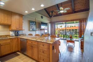 eine große Küche mit Holzschränken und einem großen Fenster in der Unterkunft Papakea E407 in Kahana