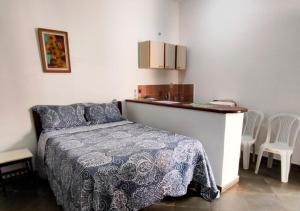 ein Schlafzimmer mit einem Bett, einem Tisch und Stühlen in der Unterkunft Suítes Jaconé - Saquarema in Jaconé