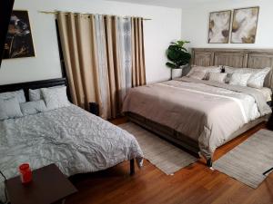 a bedroom with two beds and a table with a plant at Abiel Global Concepts LLC in Newark