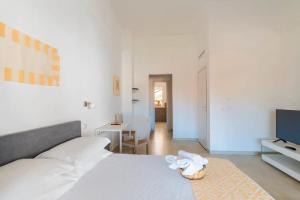 Un dormitorio blanco con una cama y una mesa. en I Centenari Longevity Rooms, en Lotzorai