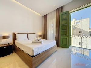 a bedroom with a bed and a large window at Malta Rooftop Villa with Private Plunge Pool & BBQ in Hal Ghaxiak