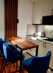 a kitchen with a wooden table and blue chairs at Apartman Felicita 2 Zlatibor in Zlatibor