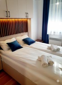 a bedroom with a large white bed with blue pillows at Apartman Felicita 2 Zlatibor in Zlatibor