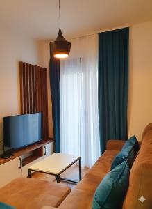 a living room with a couch and a tv at Apartman Felicita 2 Zlatibor in Zlatibor