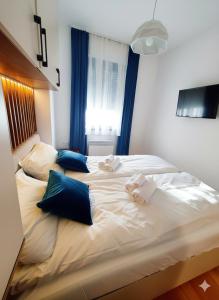 a large white bed with blue pillows on it at Apartman Felicita 2 Zlatibor in Zlatibor +3 photos