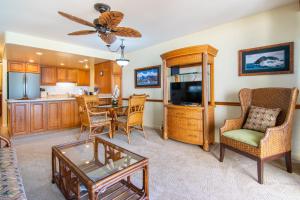 un soggiorno con tavolo e sedie e una cucina di Kahana Reef 208 a Kahana Altre 20 foto