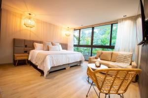 a bedroom with a bed and a chair and a couch at Hotel Salento Real Eje Cafetero in Salento