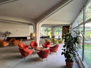 Residence Villa Alba - Suite Disposition 555 Al Vittoriale في غاردوني ريفييرا: غرفة معيشة مع كراسي برتقالية وطاولة