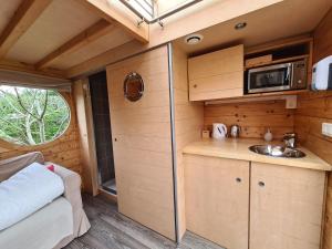 a kitchen in a tiny house with a sink at Le Carré d'Etoiles / Domaine de la Crapaudine in Rosnay