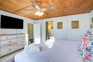 フォーリービーチにあるJust Beachyのベッドルーム1室(ベッド1台、天井ファン、テレビ付)
