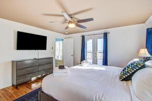 フォーリービーチにあるJust Beachyのベッドと薄型テレビのある寝室