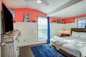 フォーリービーチにあるJust Beachyのオレンジ色の壁と青いラグが敷かれたベッドのある寝室