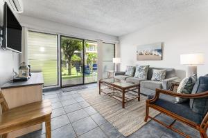 un soggiorno con un divano e un tavolo di Kihei Akahi B102 a Wailea